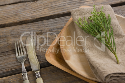 Flora and napkin arranged on plate with cutlery