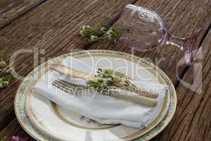 Fork and butter knife with flower and napkin on wooden table