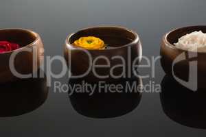 Red, white and yellow roses in glass bowls with water