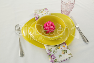 Rose flower in a bowl with cutlery