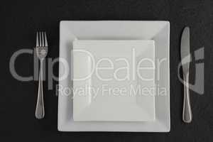 Square plates and cutlery set on a table