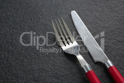 Fork and butter knife on black background