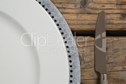 Plate with butter knife on wooden table