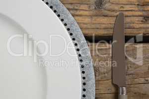 Plate with butter knife on wooden table
