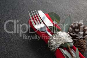 Fork, butter knife, leaf and napkin with pine cone