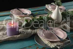Elegance table setting with flower vase and lit candle