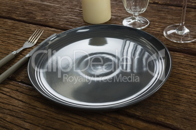 Plate with cutlery, candle and wine glass