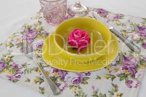 Rose flower in a bowl with cutlery