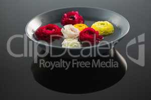 Red, white and yellow roses in glass bowl with water