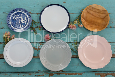 Empty plates with flower on wooden table