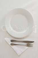 Empty plate with fork, butter knife and napkin
