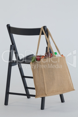 Fresh vegetables bag hanging on black chair Fresh vegetables bag hanging on black chair