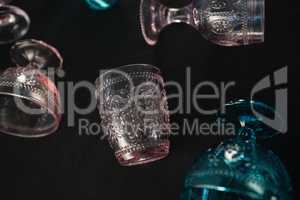 Colored glass and cups against a black background