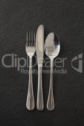 Fork, spoon and knife on black background