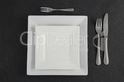 Square plates and cutlery set on a table