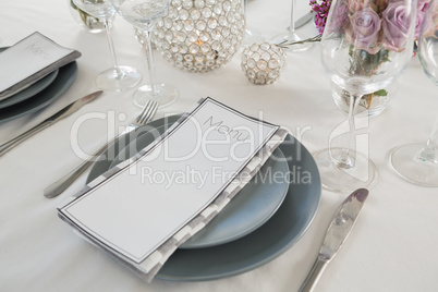 Menu card, plate and cutlery set elegantly on a table