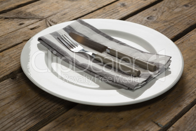 Fork and butter knife with napkin arranged in a plate