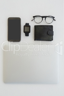 Various gadgets, spectacles and wallet on white background