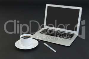 Cup of coffee, laptop and pen on black background