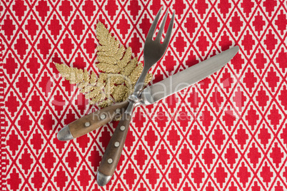 Christmas ornament with fork and butter knife on table cloth