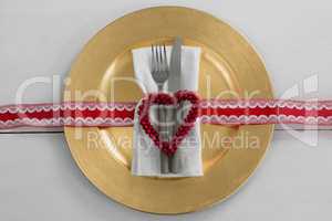 Cutlery with napkin and christmas decoration in a plate