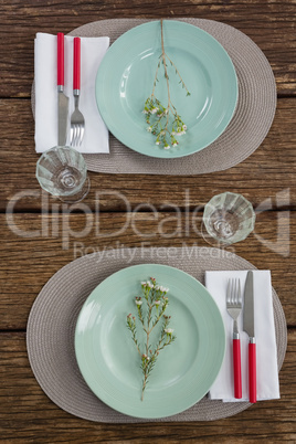 Fork and butter knife with napkin and flower on plate
