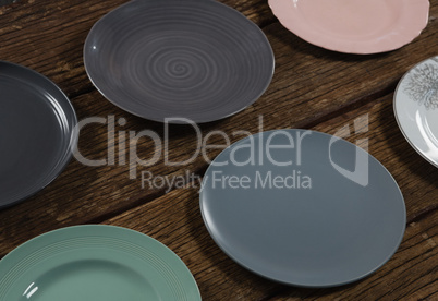 Various empty plates on wooden plank