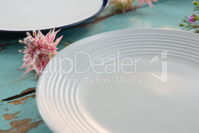 Empty plate with flower on wooden table