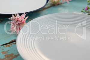 Empty plate with flower on wooden table