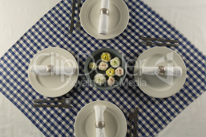 Rolled up napkin with flower decoration arranged on table