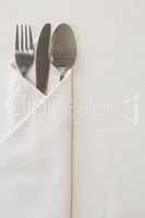 Spoon, knife and fork wrapped in a napkin