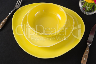 Table setting with yellow bowl and plates