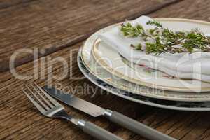 Fork and butter knife with napkin and flower arranged in a plate