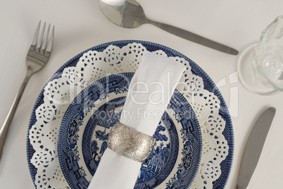 Fork, butter knife, spoon, napkin and lace placemat