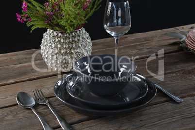 Setting a table for a dinner party with wine glass and flower vase