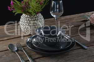 Setting a table for a dinner party with wine glass and flower vase