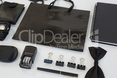 Electronic gadgets and black hued office accessories on white background