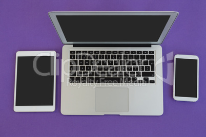 Laptop, mobile phone and digital tablet on purple background