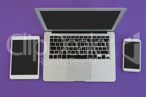 Laptop, mobile phone and digital tablet on purple background