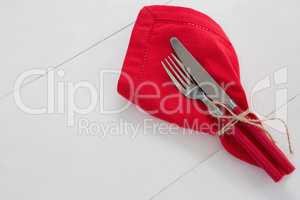 Fork and butter knife with napkin tied up with a rope