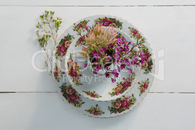 Plate and bowl with flower on white background