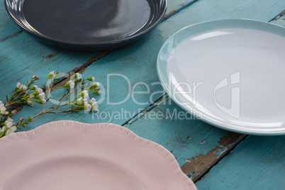 Empty plates with flower on wooden table