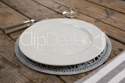 Plate and napkin with fork and butter knife on wooden table