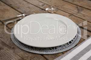 Plate and napkin with fork and butter knife on wooden table