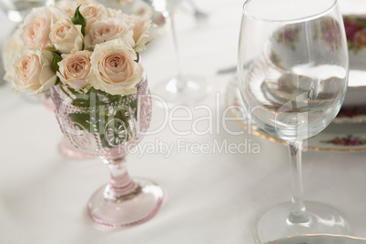 Wine glass and flowers set on a dining table