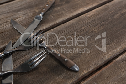 Various cutlery on wooden plank