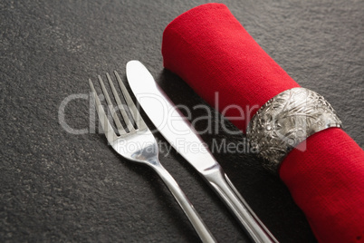 Fork and butter knife and napkin on concrete background