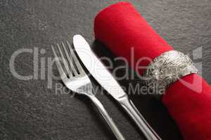 Fork and butter knife and napkin on concrete background