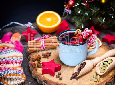 Mulled wine in an iron blue mug and drink ingredients