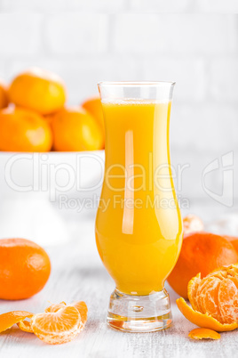 Tangerines, peeled tangerines and tangerine juice in glass. Mandarine juice.